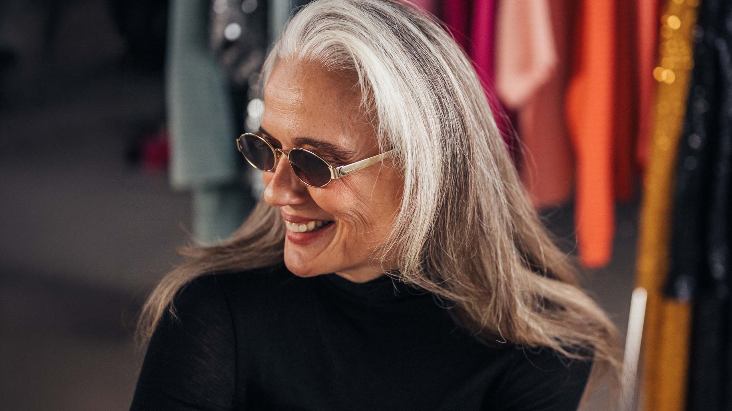 Keski-ik&auml;inen nainen jolla on trendikk&auml;&auml;t aurinkolasit.