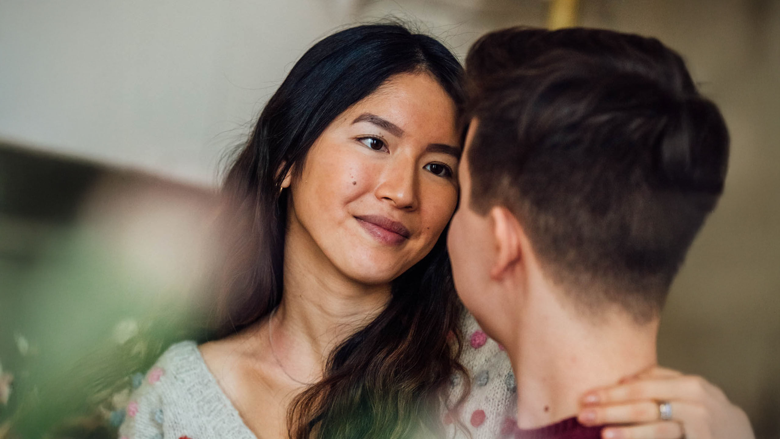 Nuori nainen jolla on piilolinssit katsoo miest&auml; ja hymyilee.