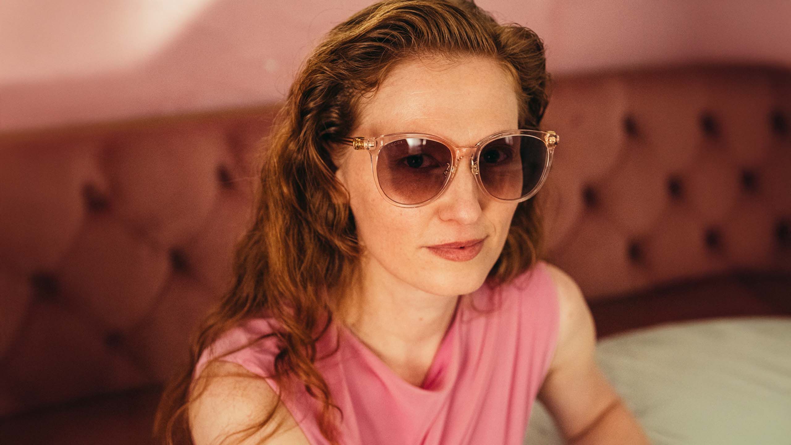 Nainen istuu ravintolassa aurinkolasit p&auml;&auml;ss&auml;.