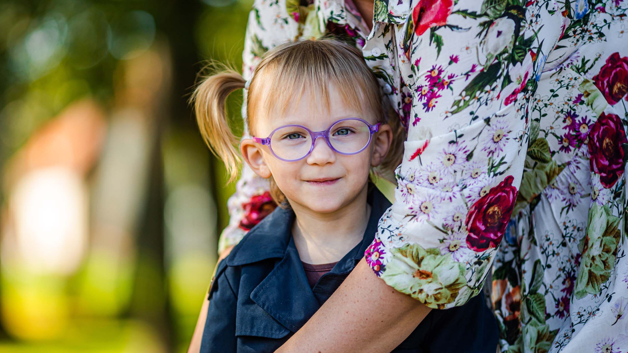 Silm&auml;lasip&auml;inen lapsi ulkona kameraan katsoen