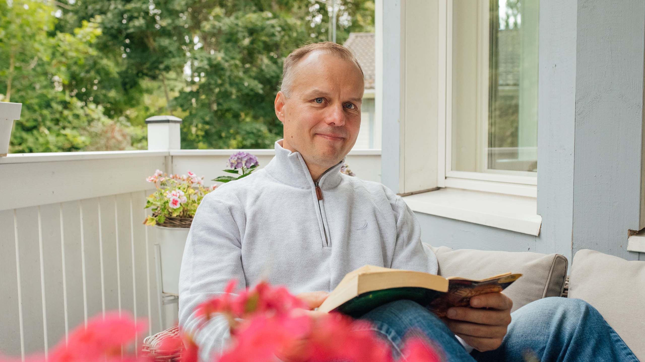 Silm&auml;leikkauksessa k&auml;ynyt mies lukee kirjaa terassilla