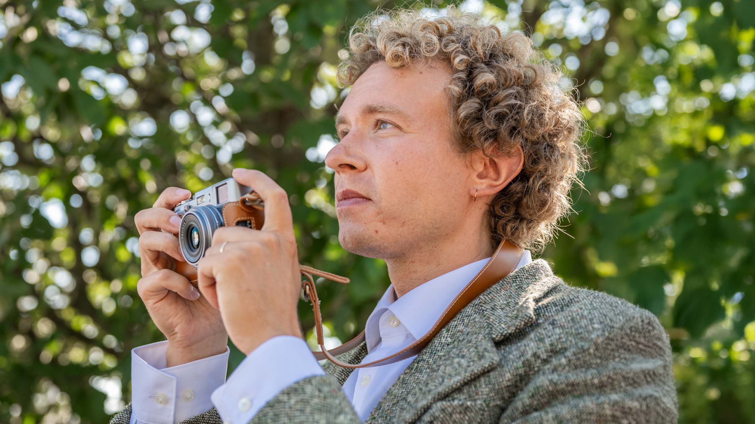 Piilolinssej&auml; k&auml;ytt&auml;v&auml; mies ulkona kameran kanssa.