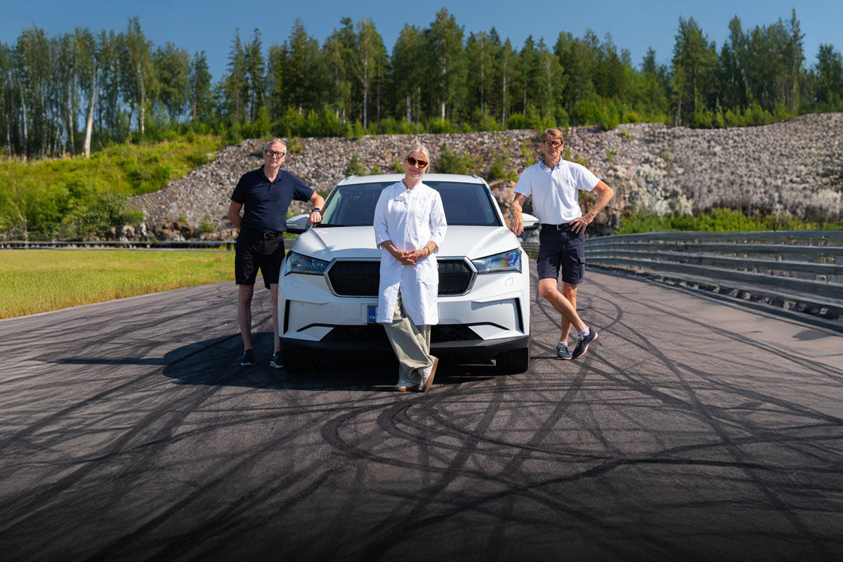 Marcus Grönholm, Timo Rautiainen ja Ulla Näpänkangas auton edessä