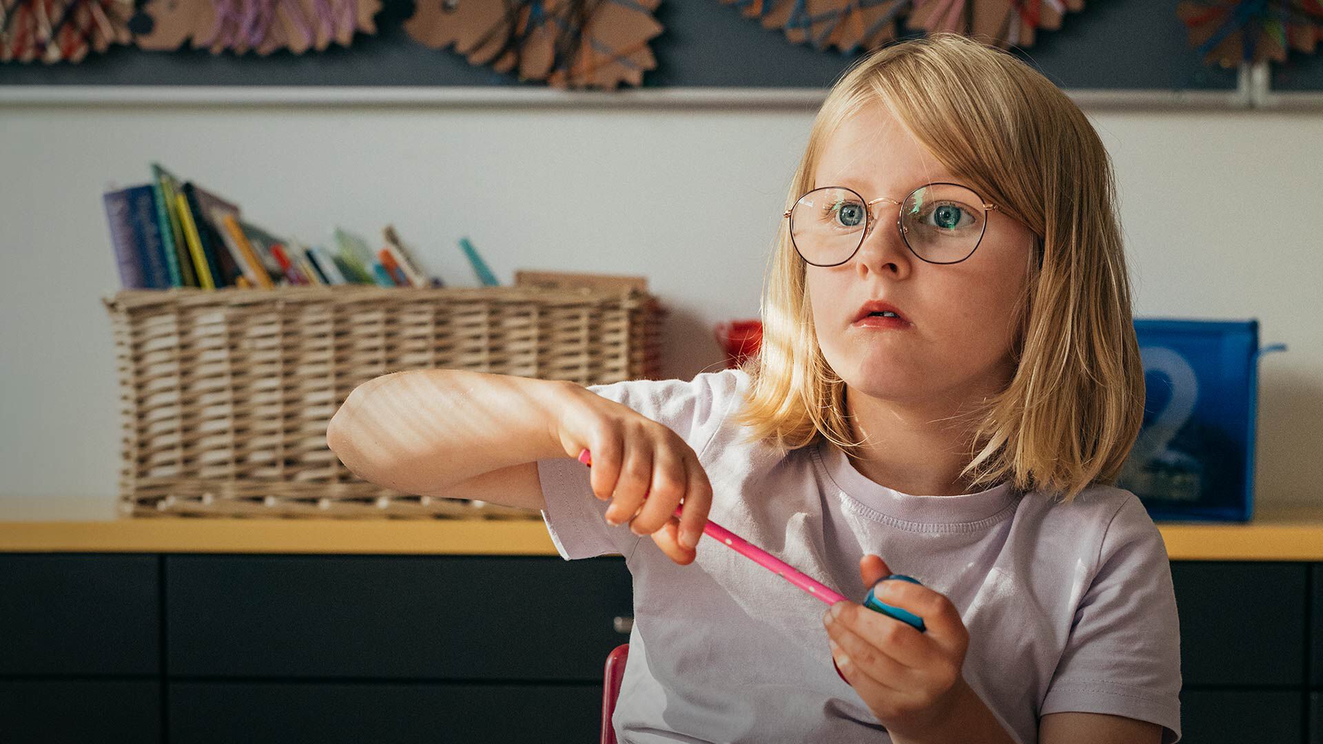 Ekaluokkalainen silm&auml;lasit p&auml;&auml;ss&auml; luokkahuoneessa 
