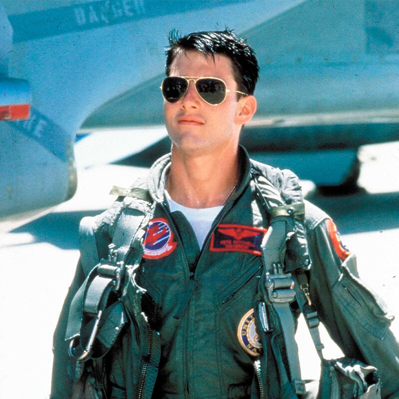  Top Gun elokuvassa mies seisoo lentokoneen vieress&auml;, kasvoilla pilottimalliset aurinkolasit