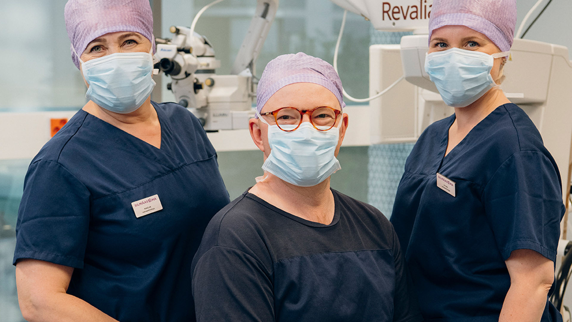 Silmäkirurgi ja silmähoitajat leikkaussalissa leikkausvarusteissa