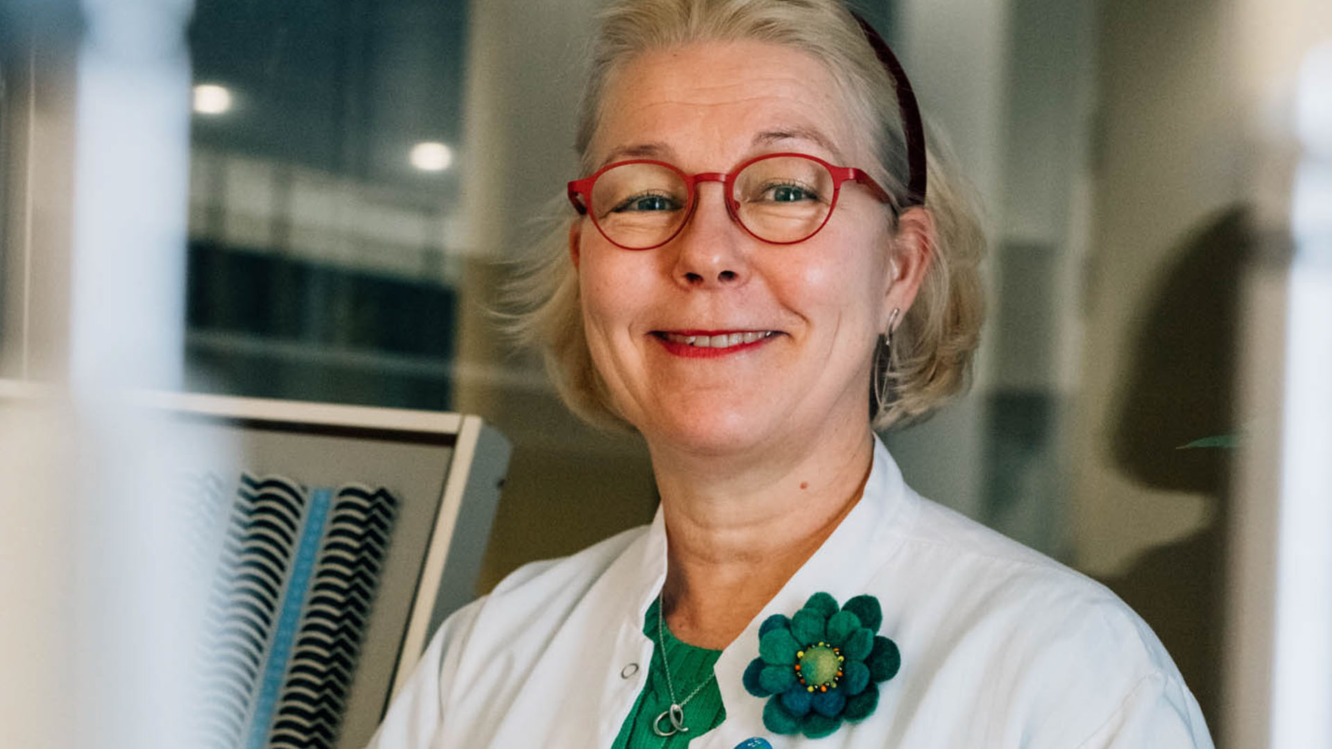 Lasten silmälääkäri hymyilee kameralle.