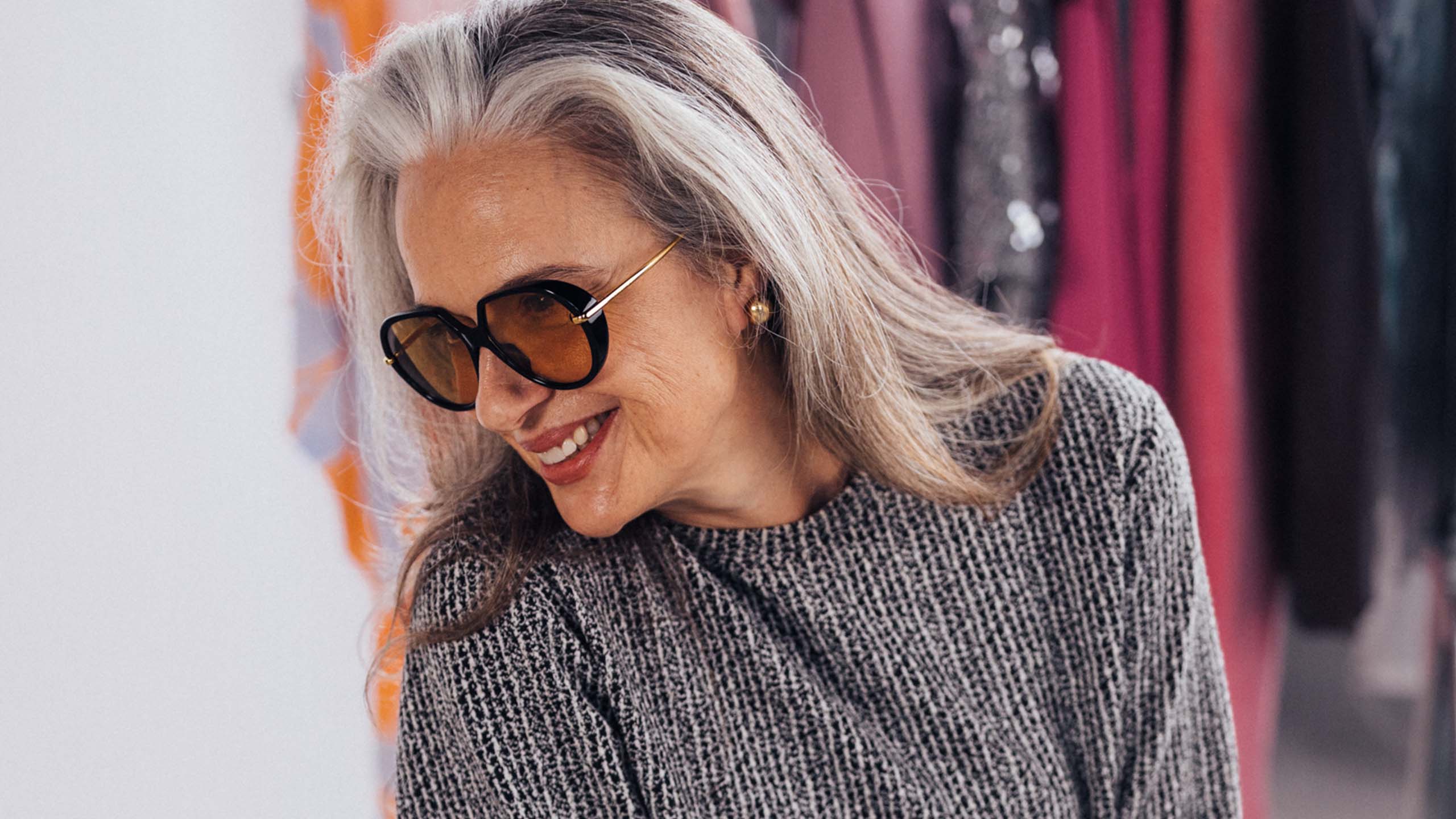 Design-aurinkolasit kasvoilla oleva nainen auringossa.