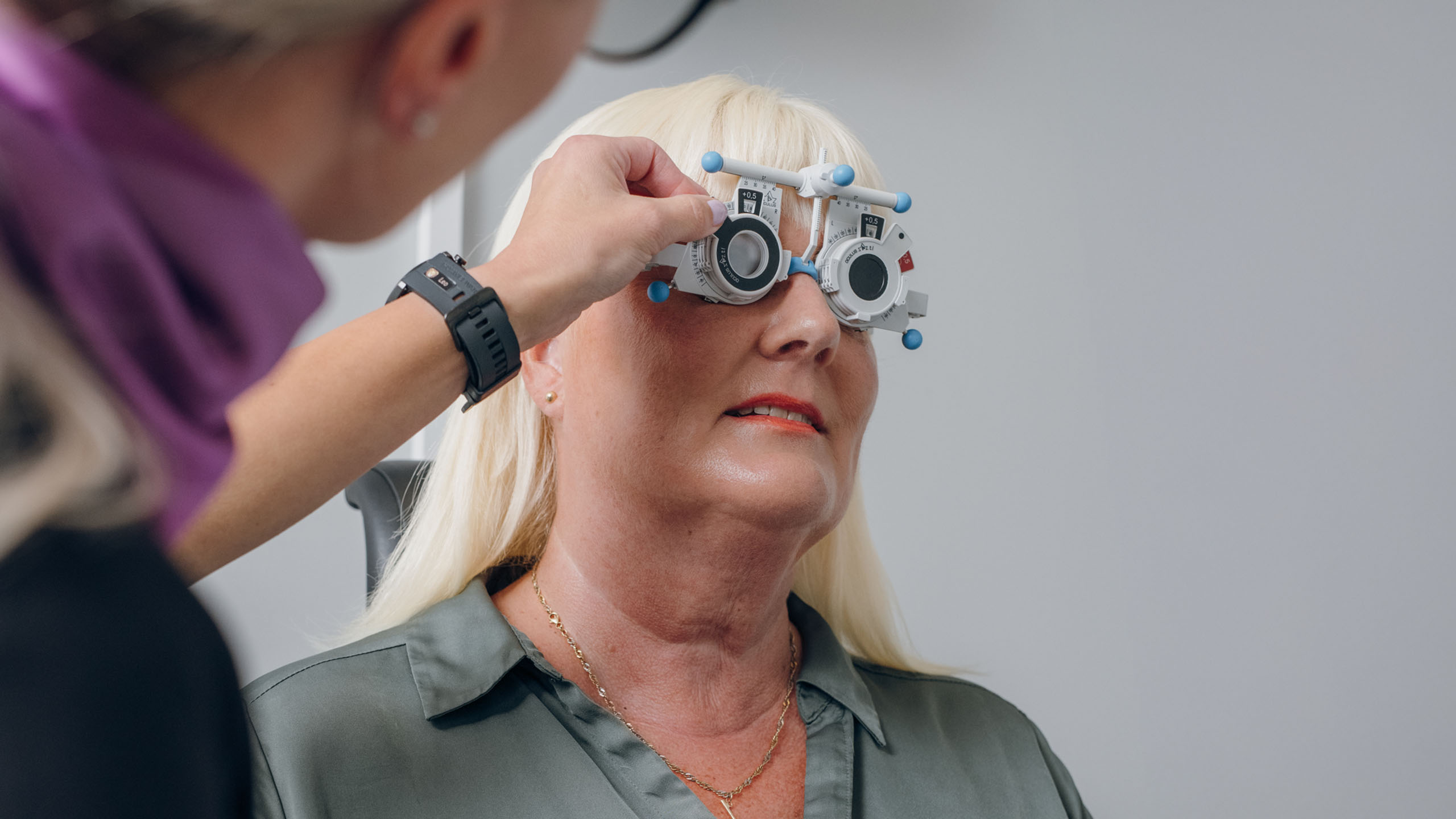 Koekehykset kasvoillaan oleva asiakas näöntutkimuksessa