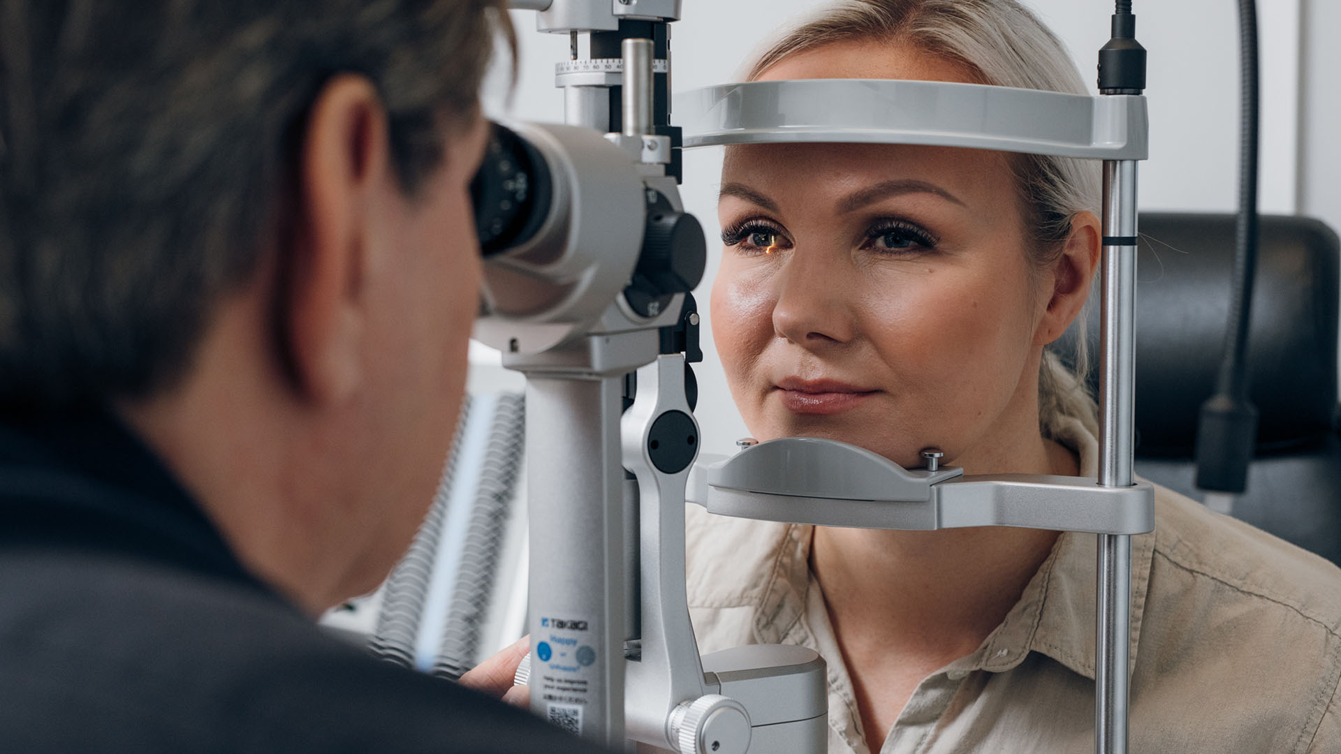 Optikko katsoo asiakkaan silmiä mikroskoopilla