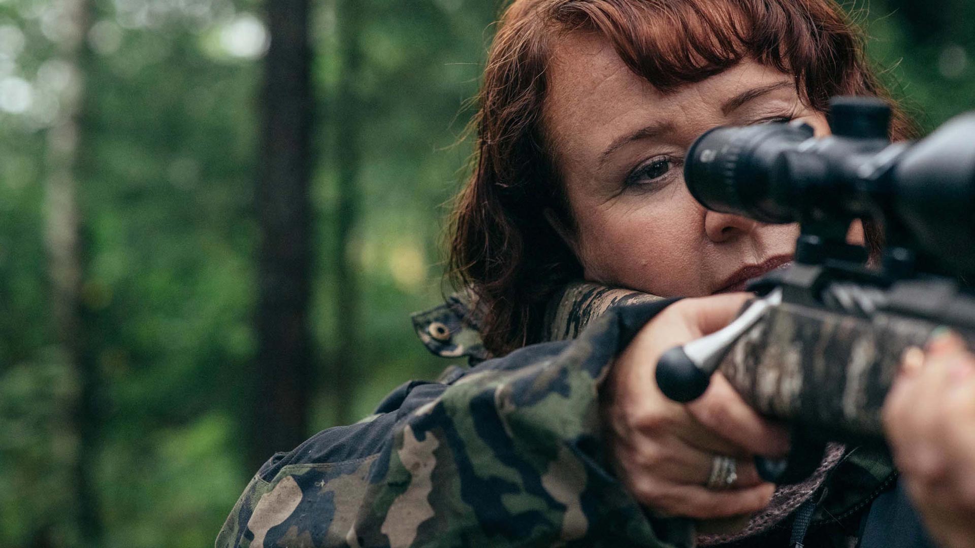 Hämäränäkö kunnossa oleva metsästäjä tähtää metsässä