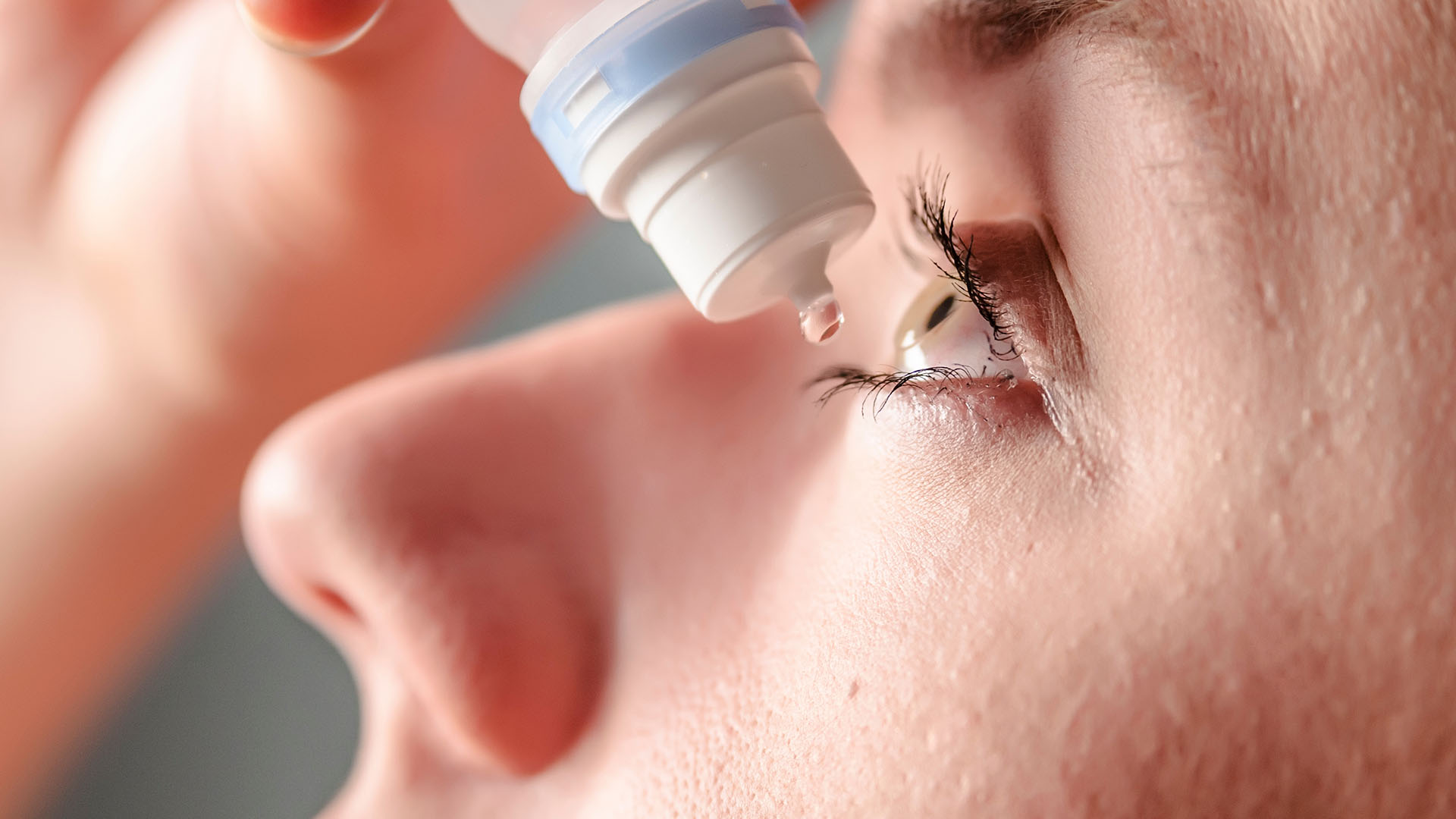 Silmätippaa silmään laittava nainen