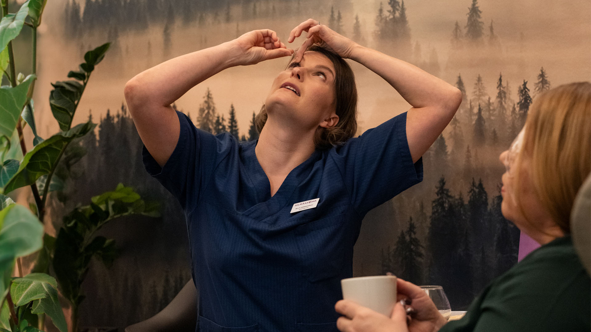 Silmähoitaja opettaa asiakasta laittamaan silmätippoja