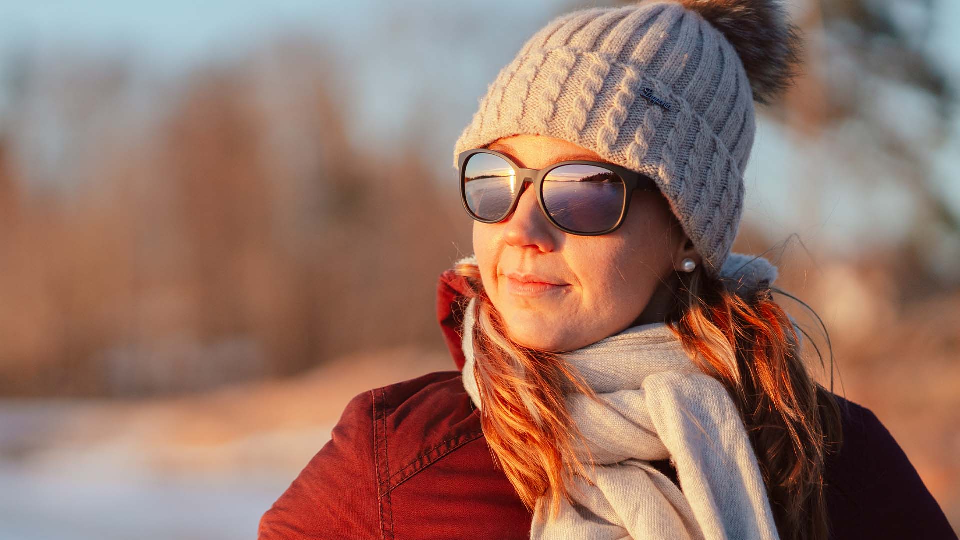 Kuivasilmäisyyttä talvella aurinkolaseilla suojaava nainen