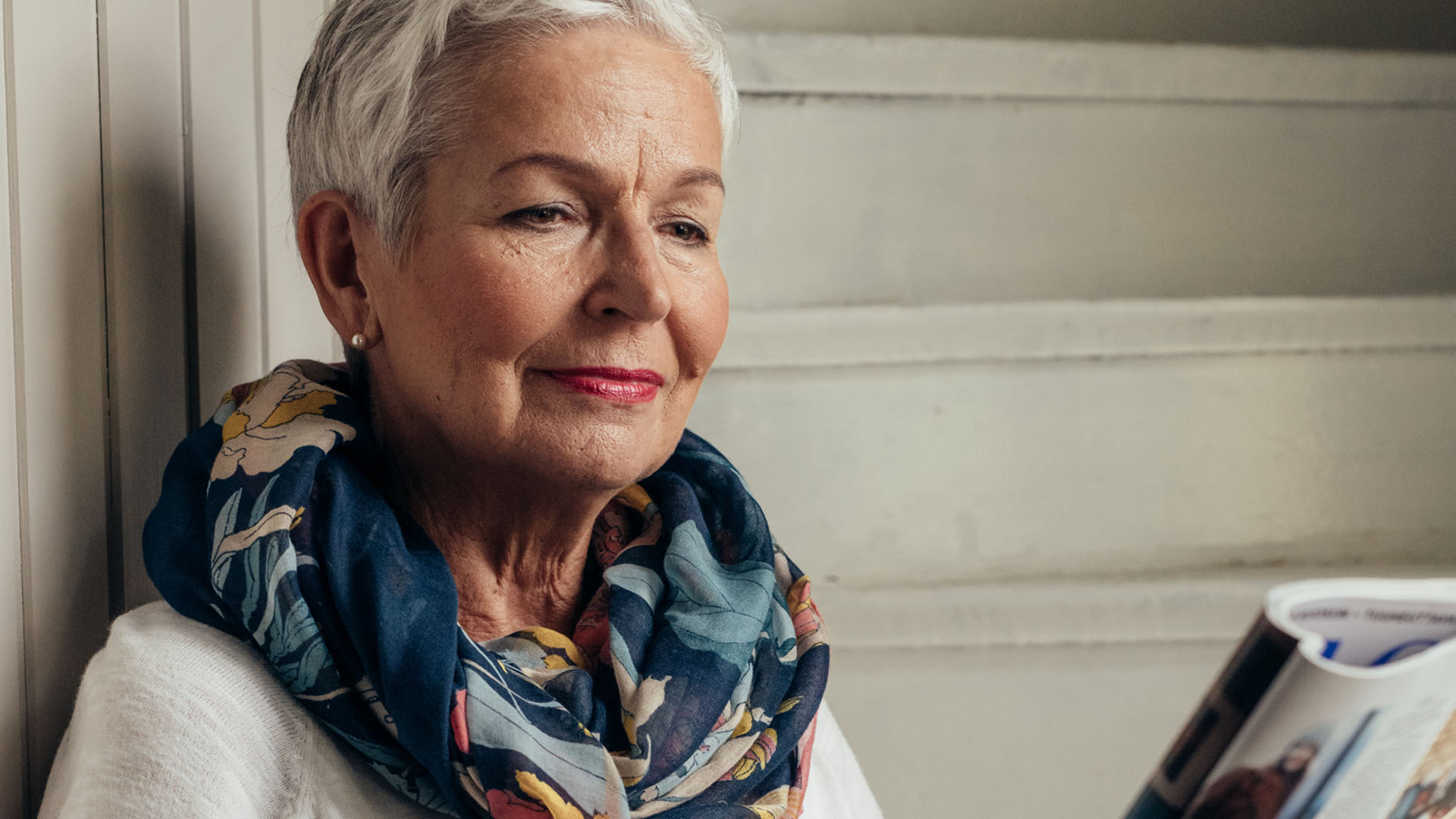 Kaihileikkauksessa käynyt nainen lukee lehteä ilman silmälaseja