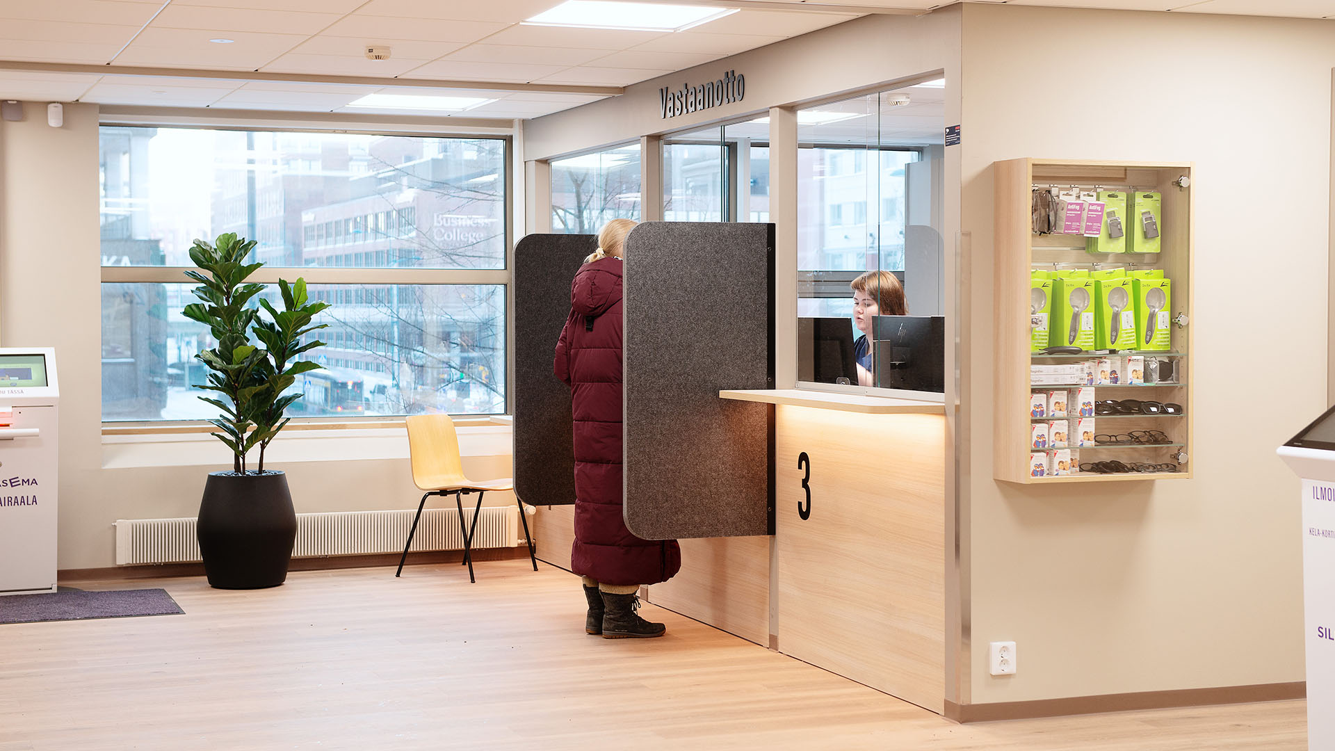 Silmäsairaala Pasilan vastaanottotiski, asiakas ja vastaanoton työntekijä