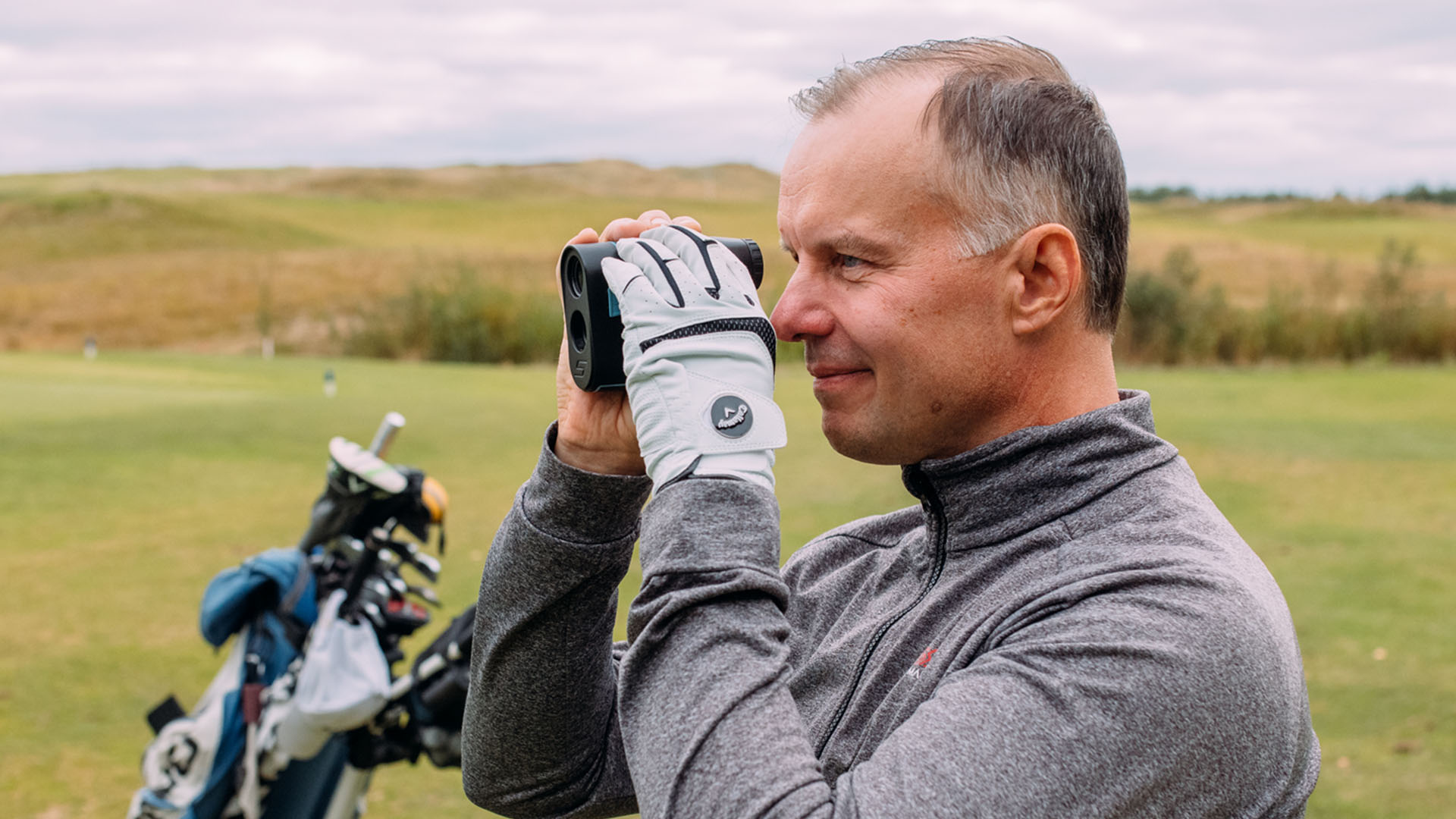Linssileikkauksessa käynyt mies golfkentällä ilman silmälaseja.