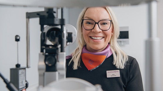 Optikko näöntarkastushuoneessa aloittamassa urheilunäöntutkimusta
