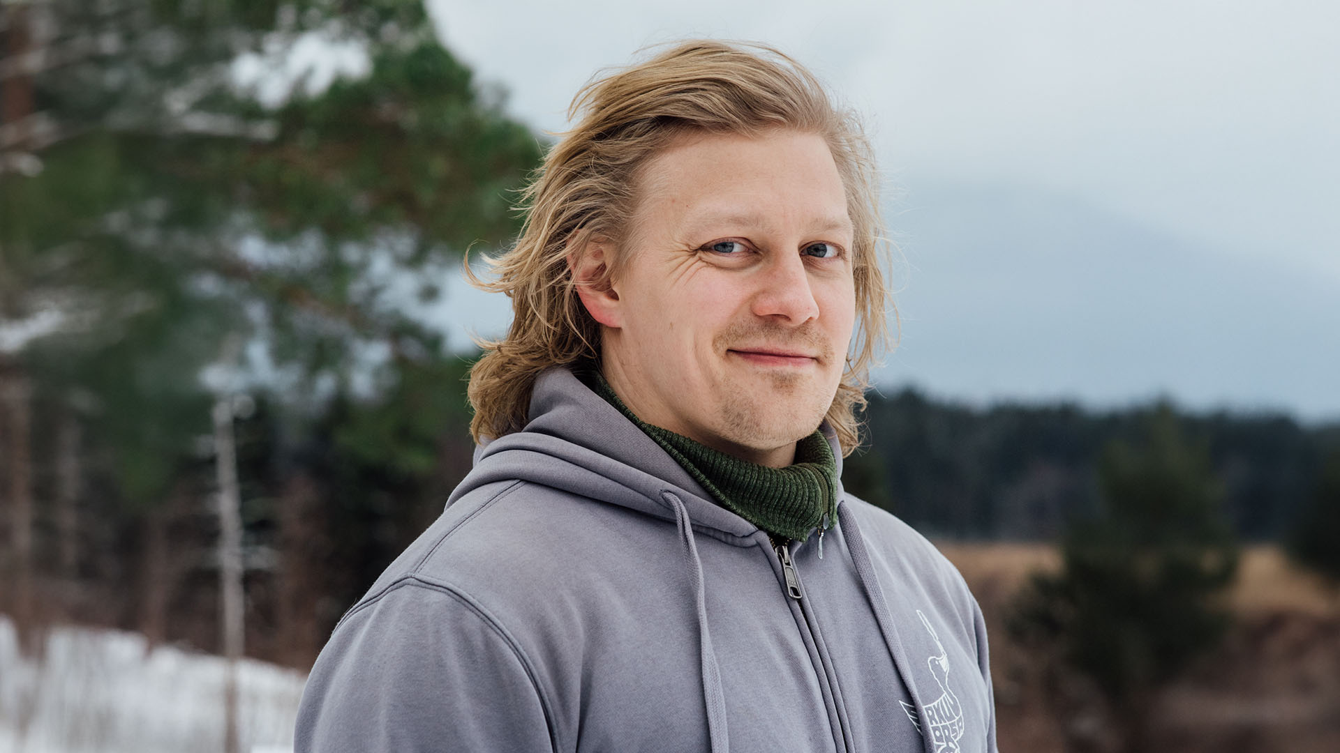 ICL-leikkauksessa käynyt Jere hymyilee kameralle harmaassa hupparissa