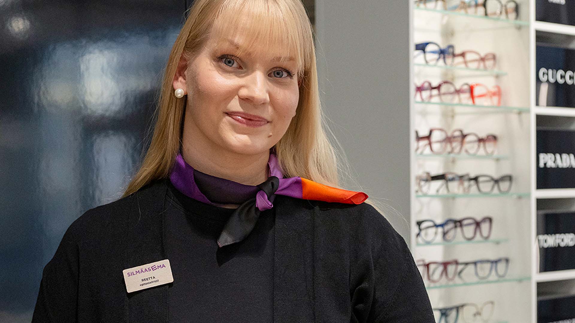 An optician smile at the camera in the store.