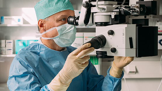 Mieskirurgi leikkauslaitteen äärellä