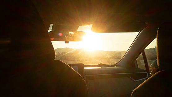 Auton tuulilasista näkymä auringonlaskuun